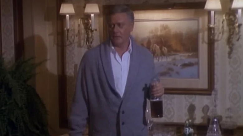 J.R. Ewing (Larry Hagman) holds a bottle of whiskey in Dallas (1978)