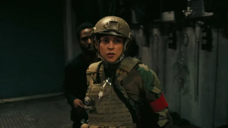 Fiona Dourif as Wheeler standing in front of John David Washington as The Protagonist in Tenet